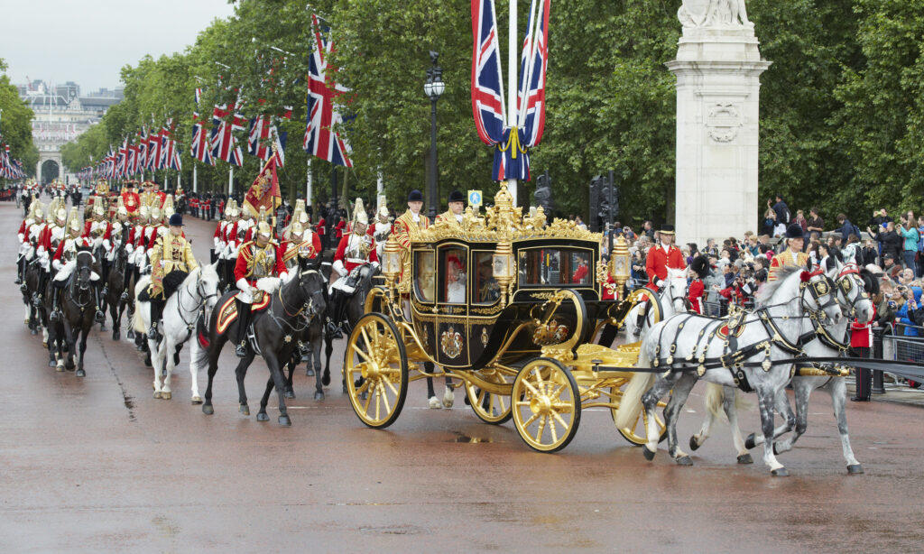 An action shot of the State Opening of Parliament, with The Queen escorted by her personal guard as she travels in the Diamond Jubilee State Coach.