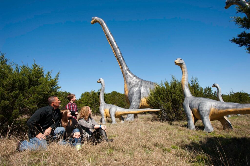 A family admiring a huge dinosaur pod at Dinosaur World